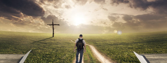 Man walking on a Bible towards a cross
